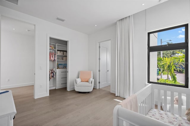 501 Barcelona Dr, Tierra Verde, FL 33715 - bedroom featuring light wood-type flooring, a walk in closet, a crib, and a closet