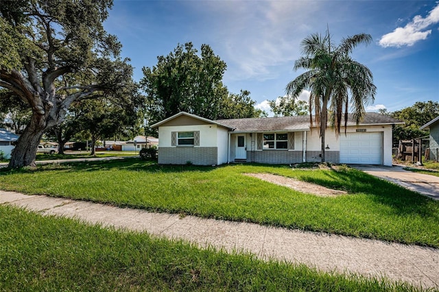 2003 Whispering Pines St, Largo, FL 33774 - ranch-style home featuring an attached garage, a front lawn, brick siding, concrete driveway, and stucco siding