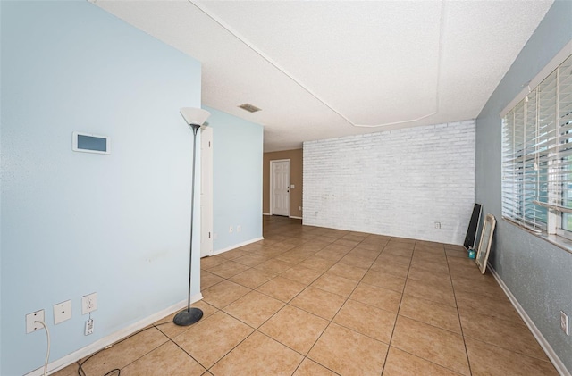 2003 Whispering Pines St, Largo, FL 33774 - spare room featuring light tile patterned floors and brick wall