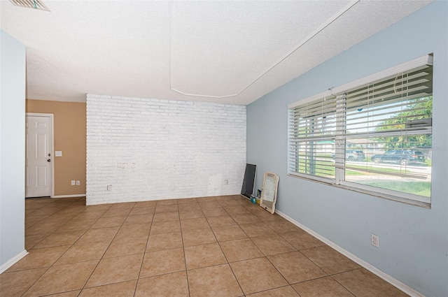 2003 Whispering Pines St, Largo, FL 33774 - empty room featuring brick wall and light tile patterned floors