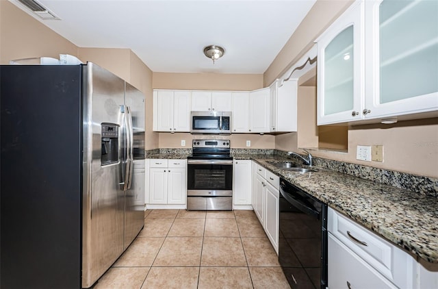 2003 Whispering Pines St, Largo, FL 33774 - kitchen featuring appliances with stainless steel finishes, white cabinets, light tile patterned floors, and glass insert cabinets