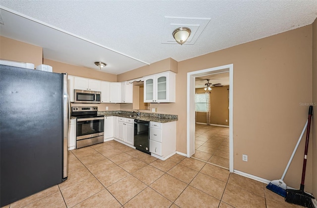 2003 Whispering Pines St, Largo, FL 33774 - kitchen with stainless steel appliances, light tile patterned floors, white cabinetry, a textured ceiling, and a ceiling fan