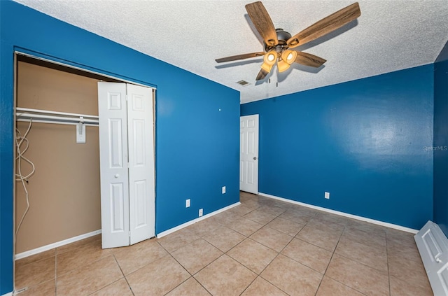 2003 Whispering Pines St, Largo, FL 33774 - unfurnished bedroom featuring a textured ceiling, tile patterned floors, a closet, and ceiling fan