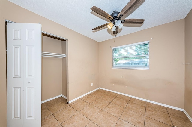 2003 Whispering Pines St, Largo, FL 33774 - unfurnished bedroom with light tile patterned floors, a closet, a textured ceiling, and ceiling fan