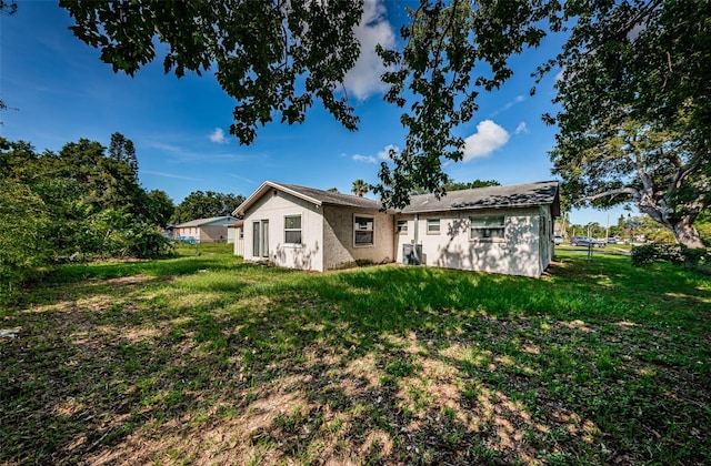 2003 Whispering Pines St, Largo, FL 33774 - rear view of house featuring a yard and stucco siding