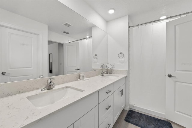 9815 Carabiner Way, Land O Lakes, FL 34637 - full bathroom with double vanity, a shower with curtain, and wood finished floors
