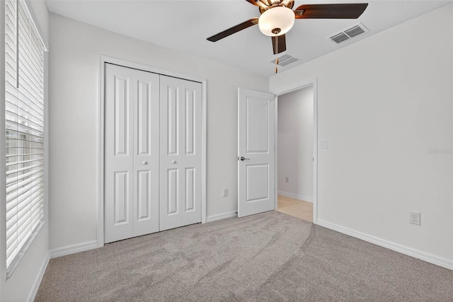 36618 Garden Wall Way, Zephyrhills, FL 33541 - unfurnished bedroom with light colored carpet, a closet, and a ceiling fan