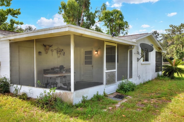 12631 Hobson Simmons Rd, Lithia, FL 33547 - view of home's exterior featuring a sunroom and a lawn