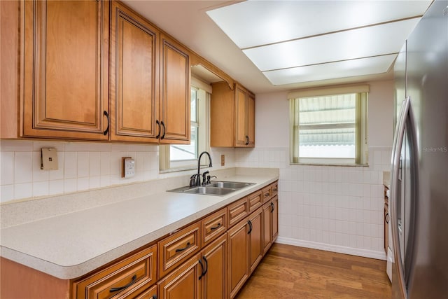 3547 Morley Dr, New Port Richey, FL 34652 - kitchen featuring freestanding refrigerator, brown cabinets, light wood-style floors, tile walls, and light countertops