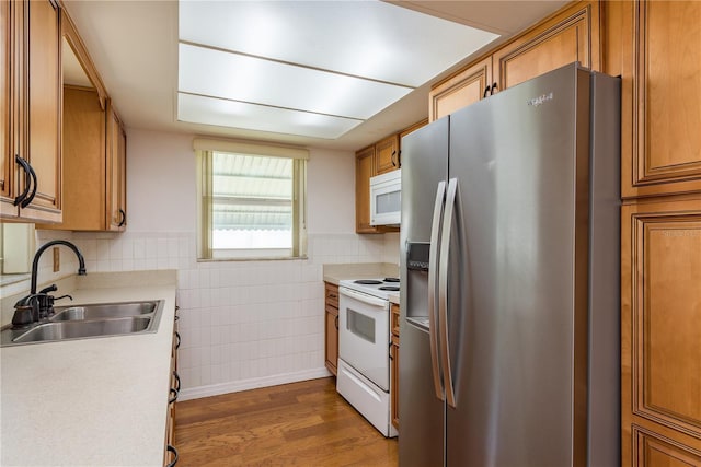 3547 Morley Dr, New Port Richey, FL 34652 - kitchen with white appliances, wood finished floors, brown cabinets, tile walls, and light countertops