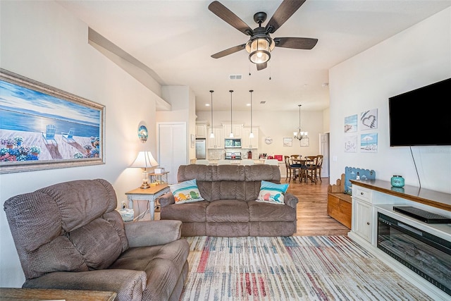 5065 Royal Palms Way Unit 303, New Port Richey, FL 34652 - living room featuring light wood-style flooring, ceiling fan, and a chandelier