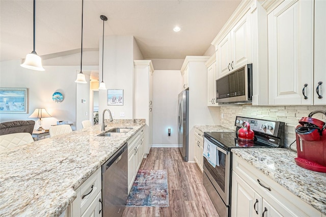 5065 Royal Palms Way Unit 303, New Port Richey, FL 34652 - kitchen featuring appliances with stainless steel finishes, light wood-type flooring, tasteful backsplash, light stone counters, and open floor plan