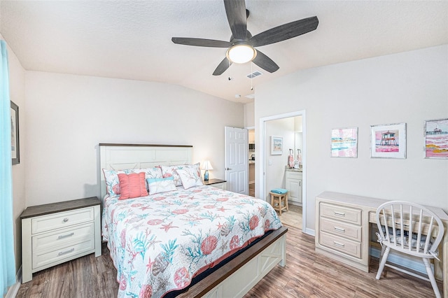 5065 Royal Palms Way Unit 303, New Port Richey, FL 34652 - bedroom featuring wood finished floors, vaulted ceiling, a desk, a ceiling fan, and ensuite bathroom