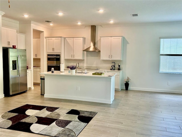 10864 Banyan Breeze Blvd, Land O Lakes, FL 34638 - kitchen featuring appliances with stainless steel finishes, wall chimney range hood, light countertops, white cabinets, and crown molding