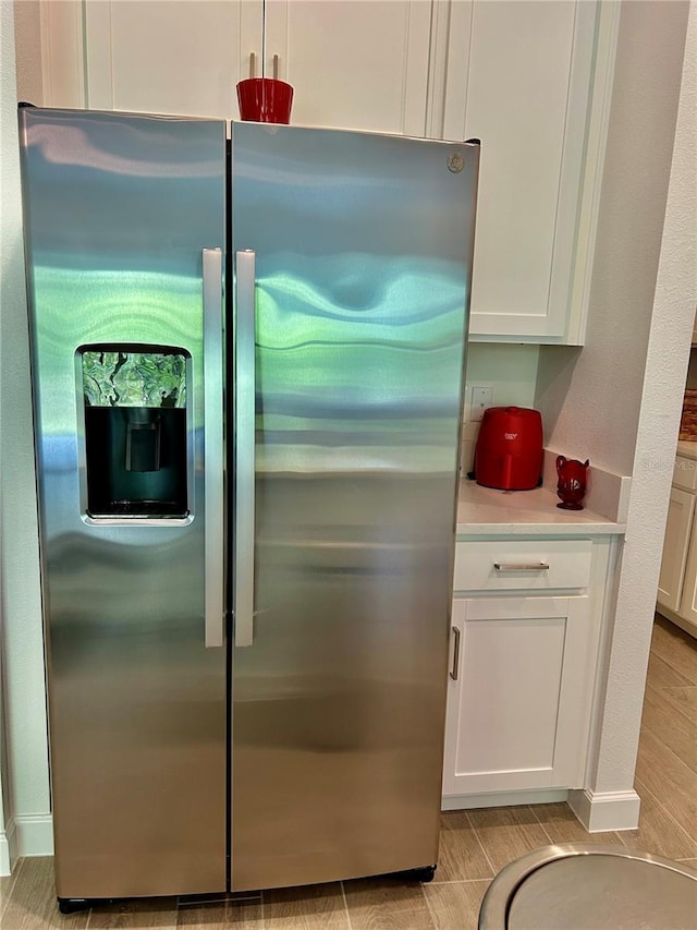 10864 Banyan Breeze Blvd, Land O Lakes, FL 34638 - detailed view of stainless steel refrigerator with ice dispenser, light countertops, and white cabinets