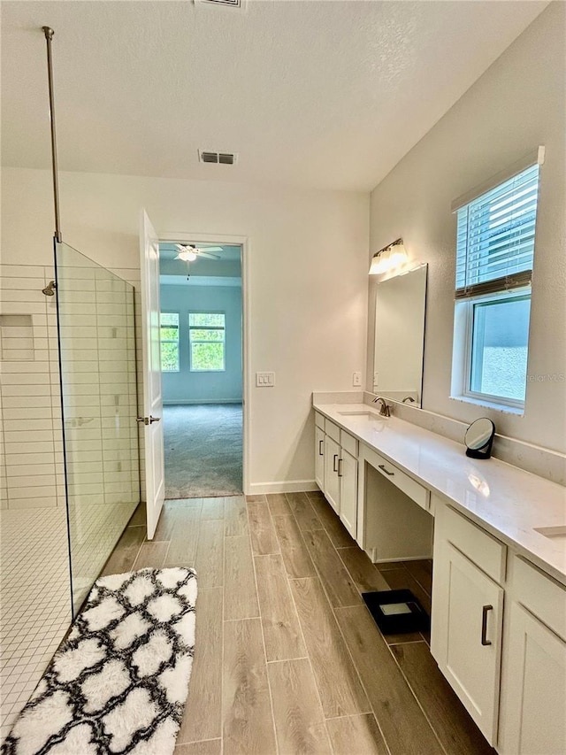 10864 Banyan Breeze Blvd, Land O Lakes, FL 34638 - full bathroom featuring wood finish floors, double vanity, walk in shower, and a ceiling fan