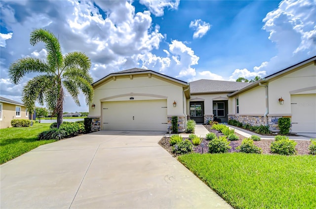 11619 Cambium Crown Dr, Riverview, FL 33569 - view of front of home with stucco siding, stone siding, driveway, an attached garage, and a front yard