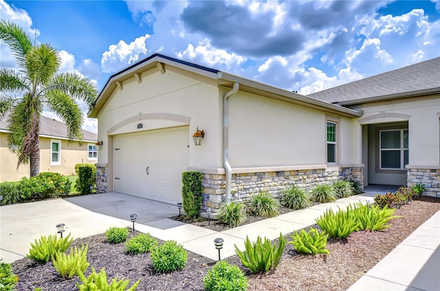 11619 Cambium Crown Dr, Riverview, FL 33569 - view of home's exterior with stone siding, concrete driveway, stucco siding, and an attached garage