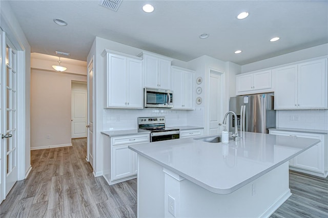 11619 Cambium Crown Dr, Riverview, FL 33569 - kitchen with stainless steel appliances, backsplash, light wood-type flooring, white cabinets, and recessed lighting