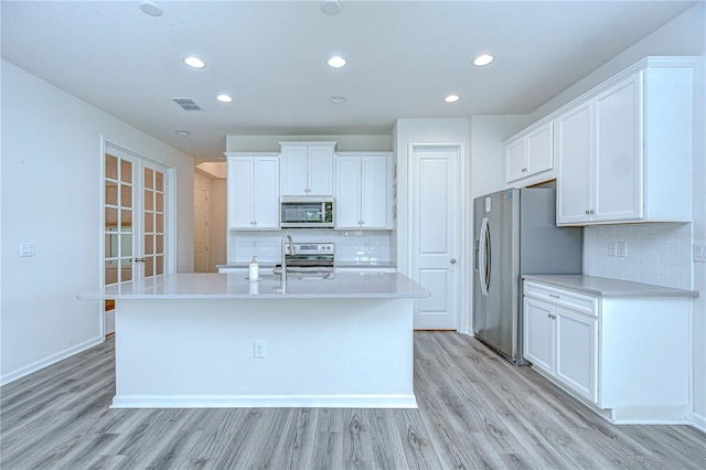 11619 Cambium Crown Dr, Riverview, FL 33569 - kitchen featuring stainless steel appliances, decorative backsplash, light wood-style floors, white cabinetry, and recessed lighting