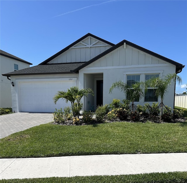 11717 74th Cir E, Palmetto, FL 34221 - view of front of property with a garage, board and batten siding, decorative driveway, a front yard, and roof with shingles