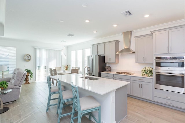 11717 74th Cir E, Palmetto, FL 34221 - kitchen featuring gray cabinetry, appliances with stainless steel finishes, wall chimney range hood, a breakfast bar area, and recessed lighting