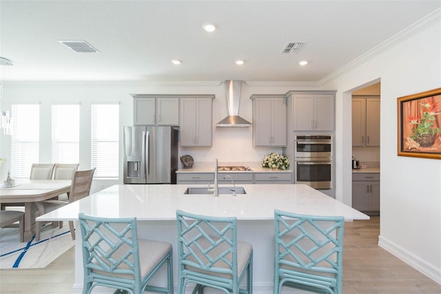 11717 74th Cir E, Palmetto, FL 34221 - kitchen featuring gray cabinetry, appliances with stainless steel finishes, wall chimney exhaust hood, ornamental molding, and an island with sink