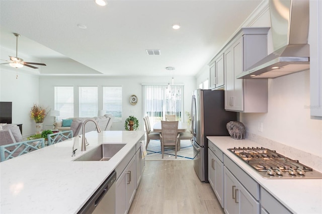 11717 74th Cir E, Palmetto, FL 34221 - kitchen featuring wall chimney range hood, stainless steel appliances, open floor plan, ceiling fan, and light wood-type flooring