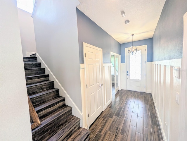 32599 Natural Bridge Rd, Wesley Chapel, FL 33543 - foyer entrance featuring stairway, dark wood-type flooring, a chandelier, and wainscoting