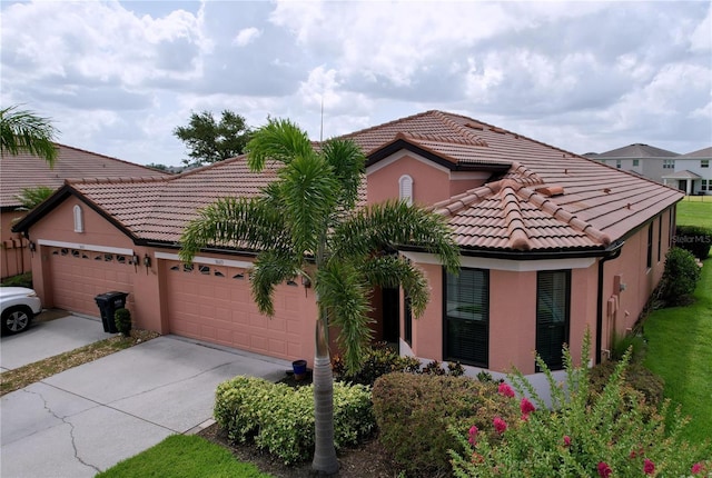 5663 Sunset Falls Dr, Apollo Beach, FL 33572 - view of front of property featuring an attached garage, concrete driveway, a tile roof, and stucco siding