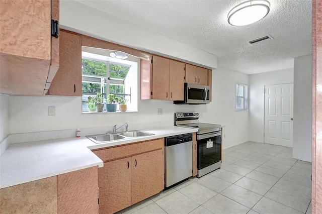 1903 24th St, Sarasota, FL 34234 - kitchen with stainless steel appliances, light countertops, a textured ceiling, and light tile patterned floors