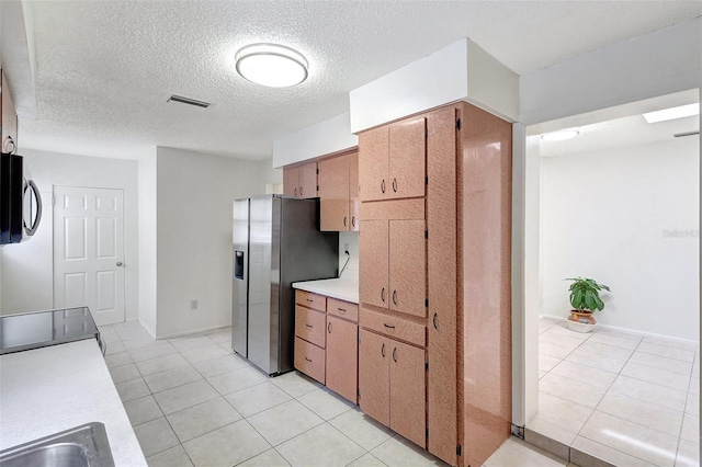 1903 24th St, Sarasota, FL 34234 - kitchen with appliances with stainless steel finishes, light countertops, light tile patterned flooring, and a textured ceiling