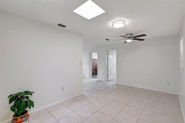 1903 24th St, Sarasota, FL 34234 - unfurnished room featuring a textured ceiling, light tile patterned floors, a ceiling fan, and a skylight