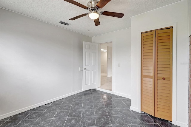 1903 24th St, Sarasota, FL 34234 - unfurnished bedroom with a textured ceiling, dark tile patterned floors, ceiling fan, and a closet