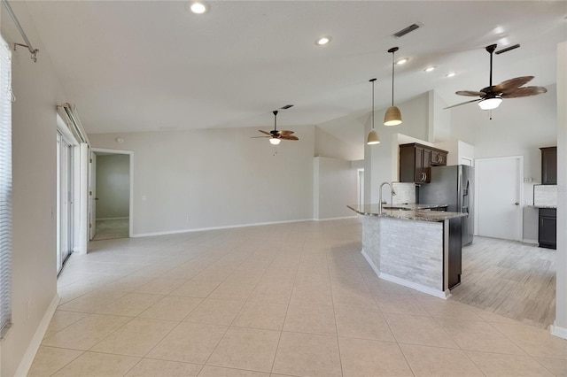 318 Lookout Dr, Apollo Beach, FL 33572 - kitchen featuring ceiling fan, dark brown cabinetry, light stone counters, stainless steel fridge with ice dispenser, and open floor plan
