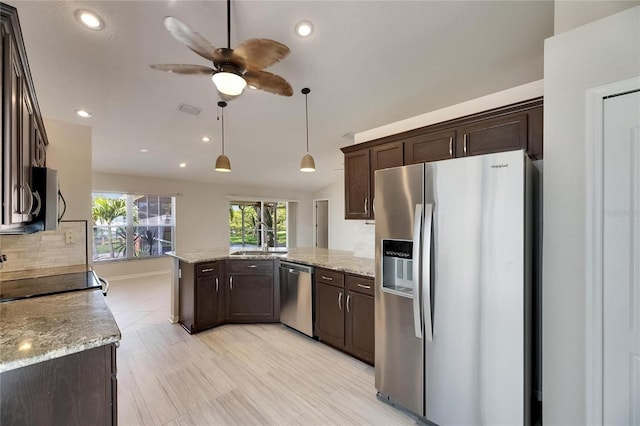 318 Lookout Dr, Apollo Beach, FL 33572 - kitchen with stainless steel appliances, a peninsula, dark brown cabinets, ceiling fan, and recessed lighting