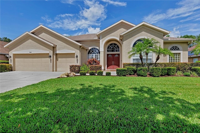 9242 Brindlewood Dr, Odessa, FL 33556 - mediterranean / spanish home featuring stucco siding, a garage, a front lawn, and driveway