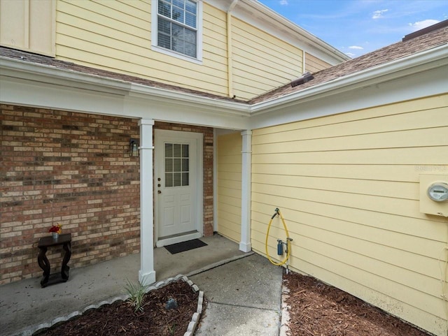 6114 Oak Cluster Cir, Tampa, FL 33634 - doorway to property featuring brick siding and roof with shingles
