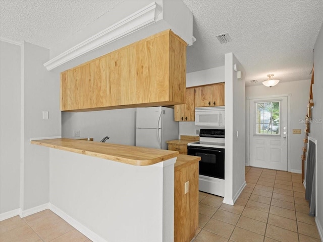 6114 Oak Cluster Cir, Tampa, FL 33634 - kitchen with white appliances, a textured ceiling, light tile patterned floors, a peninsula, and wood counters