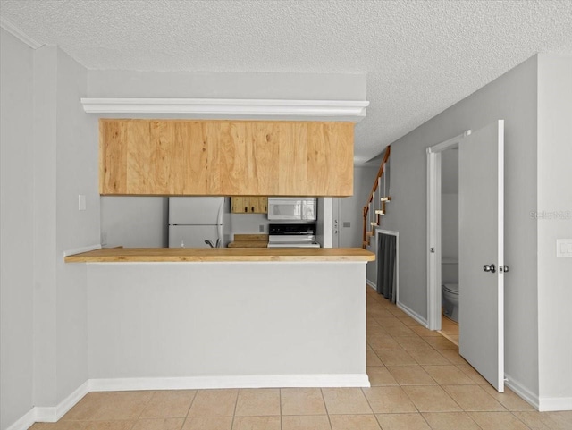 6114 Oak Cluster Cir, Tampa, FL 33634 - kitchen featuring white appliances, a textured ceiling, light tile patterned floors, a peninsula, and light countertops