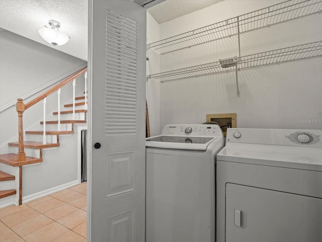 6114 Oak Cluster Cir, Tampa, FL 33634 - washroom with separate washer and dryer, light tile patterned floors, and a textured ceiling