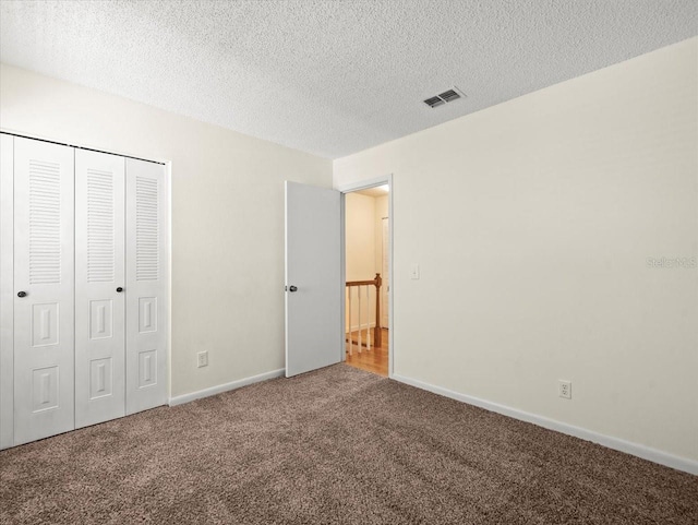 6114 Oak Cluster Cir, Tampa, FL 33634 - unfurnished bedroom featuring carpet floors, a closet, and a textured ceiling