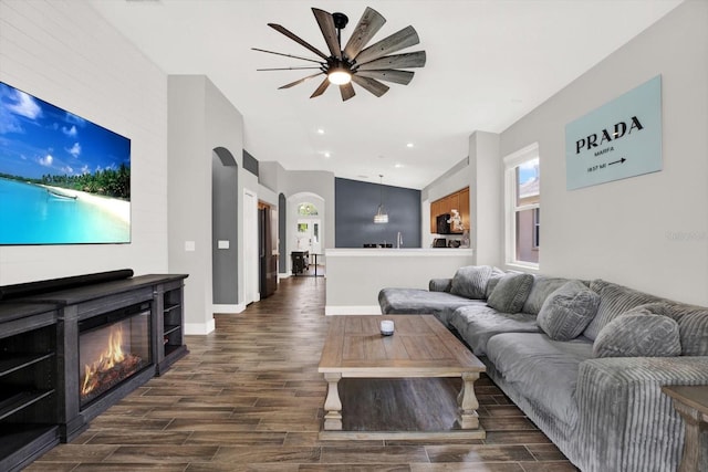4901 Windingbrook Trl, Wesley Chapel, FL 33544 - living area featuring dark wood-type flooring, a glass covered fireplace, ceiling fan, recessed lighting, and arched walkways