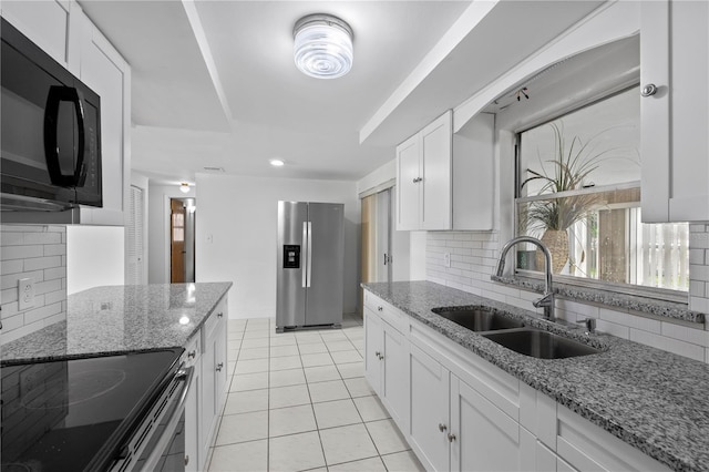 10730 Premier Ave, Port Richey, FL 34668 - kitchen with black microwave, stainless steel refrigerator with ice dispenser, backsplash, and white cabinetry