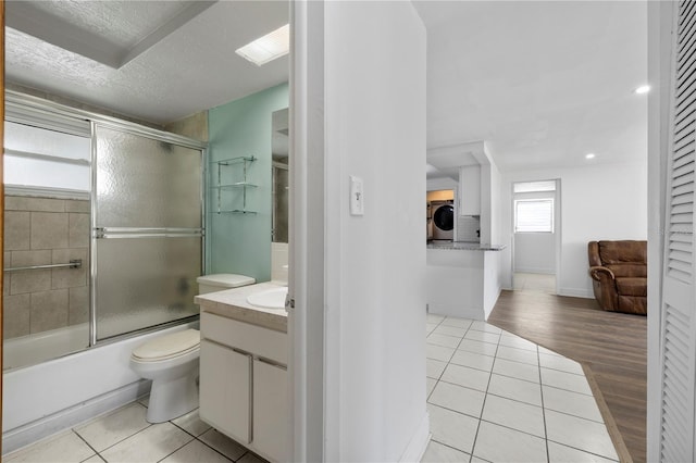 10730 Premier Ave, Port Richey, FL 34668 - bathroom with washer / clothes dryer, tile patterned flooring, vanity, combined bath / shower with glass door, and a textured ceiling
