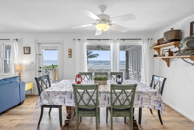 12458 1st St W, Treasure Island, FL 33706 - dining room with light wood-type flooring, a ceiling fan, a water view, and a textured ceiling