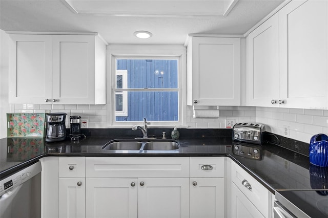 12458 1st St W, Treasure Island, FL 33706 - kitchen featuring dishwasher, white cabinetry, decorative backsplash, and dark countertops