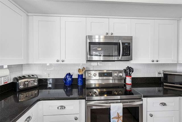 12458 1st St W, Treasure Island, FL 33706 - kitchen featuring appliances with stainless steel finishes, white cabinets, and tasteful backsplash