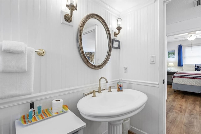 12458 1st St W, Treasure Island, FL 33706 - ensuite bathroom with crown molding, wood finished floors, and a decorative wall
