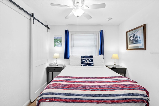 12458 1st St W, Treasure Island, FL 33706 - bedroom featuring a barn door and a ceiling fan
